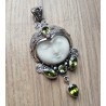 Zilveren hanger met gezicht uit been gesneden en Peridot