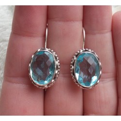 Zilveren oorbellen ovale facet blauw Topaas bewerkte setting