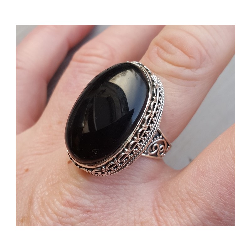 Zilveren ring met cabochon Onyx en bewerkte kop 18.5