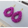 Vergulde oorbellen met open druppel van fuchsia roze kristallen