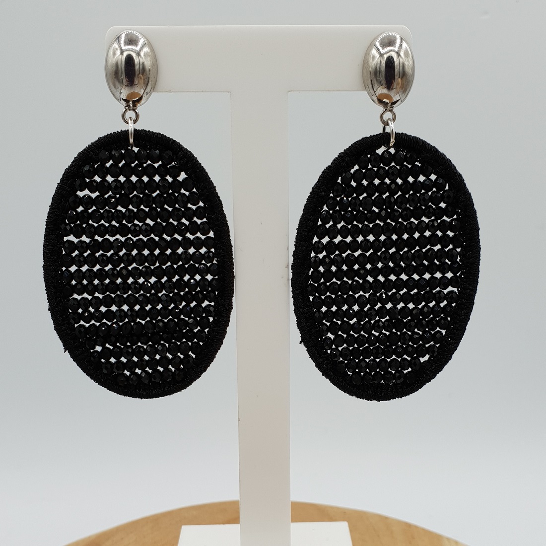 wrijving Klem Lao Oorbellen met ovale hanger van zijdedraad en zwarte kristallen | Verkocht
